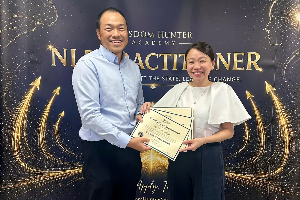 YJ presenting NLP Practitioner certificates to a participant